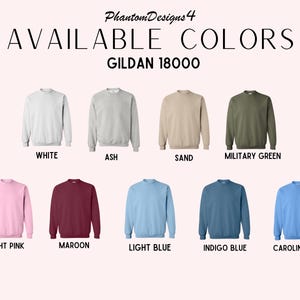 May include: A color chart showing the available colors for Gildan 18000 sweatshirts. The colors are: white, ash, sand, military green, light pink, maroon, light blue, indigo blue, and Carolina blue.