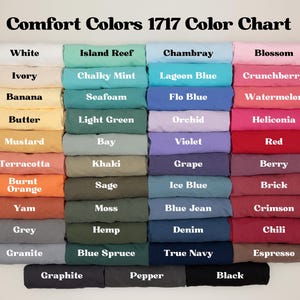 May include: Color chart titled "Comfort Colors 1717 Color Chart" displaying a variety of fabric colors. Colors include white, ivory, banana, butter, mustard, terracotta, burnt orange, yam, grey, granite, graphite, island reef, chalky mint, seafoam, light green, bay, khaki, sage, moss, hemp, blue spruce, pepper, chambray, lagoon blue, flo blue, orchid, violet, grape, ice blue, blue jean, denim, true navy, blossom, crunchberry, watermelon, heliconia, red, berry, brick, crimson, chili, espresso, and black.
