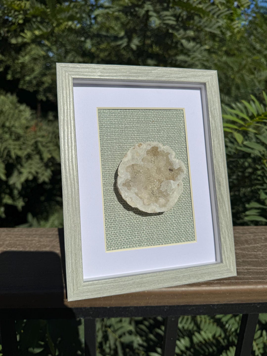 Dazzling Moroccan Geode on a Soft Green Fabric Backing on a Grey Wooden ...