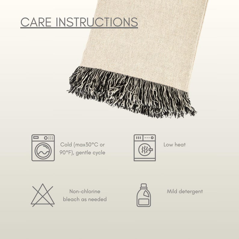 Puede incluir: Una manta de color crema con flecos negros y blancos. La imagen incluye instrucciones de cuidado: lavar en fr&iacute;o (m&aacute;x. 30&deg;C), baja temperatura, lej&iacute;a sin cloro seg&uacute;n sea necesario y detergente suave.