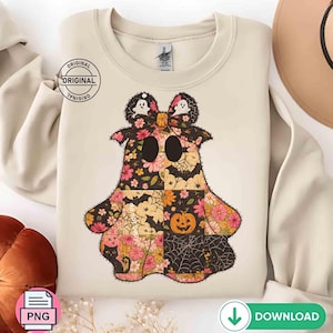 May include: Cream-coloured sweatshirt with a patchwork ghost design. The ghost features floral, spiderweb, and pumpkin patterns in pink, black, and orange. Two ghost-shaped bows top the design. The word "ORIGINAL" is printed on the upper left.