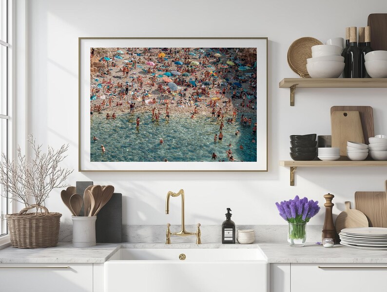 May include: An aerial photograph of a crowded beach with people swimming and sunbathing in the turquoise water. The beach is lined with colorful umbrellas and beach chairs.
