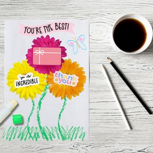 Puede incluir: Una tarjeta blanca con el texto "You're the best!" y tres flores de papel con las palabras "You are incredible", "Thank you" y una caja de regalo rosa.