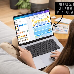 May include: A laptop displaying a design with the text "LUCKY DUCKS" and "EDIT COLORS, TEXT, FONT, & IMAGES TO MATCH YOUR SCHOOL!". The screen shows a design with yellow ducks and blue waves. The laptop is open on a person's lap.