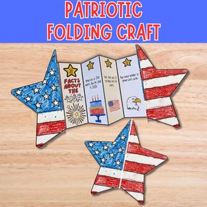 May include: Patriotic folding craft in the shape of a star, featuring the American flag design. The craft is red, white, and blue, with text that reads "Facts About The USA". The craft is displayed on a wooden surface.