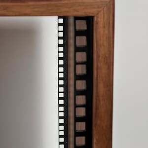 May include: Close-up of a wooden rack with black metal rails for mounting audio equipment. The rack is made of solid wood and has a natural finish.