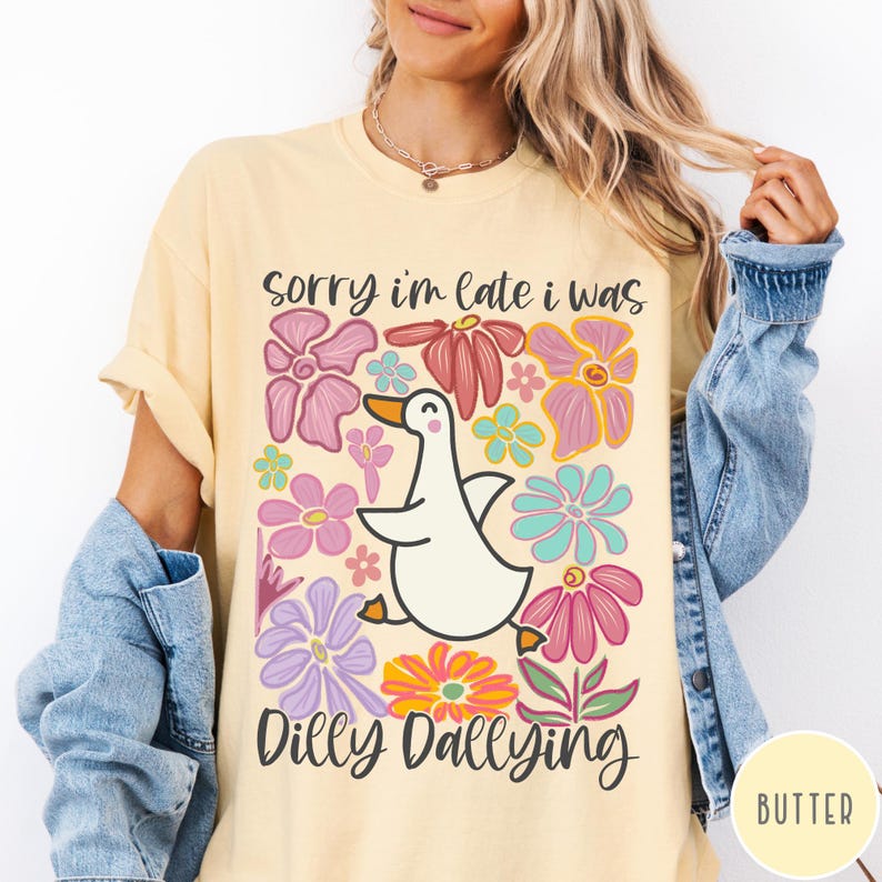 May include: A yellow t-shirt with a white duck and colorful flowers. The text on the shirt reads "Sorry I'm late I was dilly dallying."