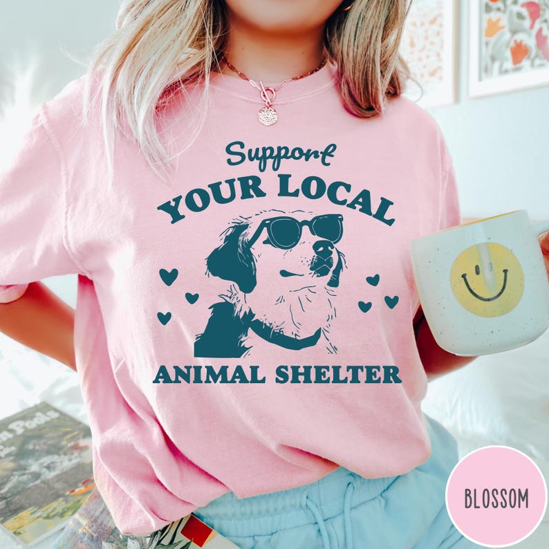 May include: Pink t-shirt with the text "Support Your Local Animal Shelter" and a graphic of a dog wearing sunglasses.