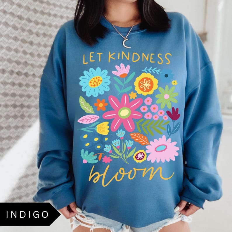 May include: A blue sweatshirt with a floral design and the text "Let kindness bloom".