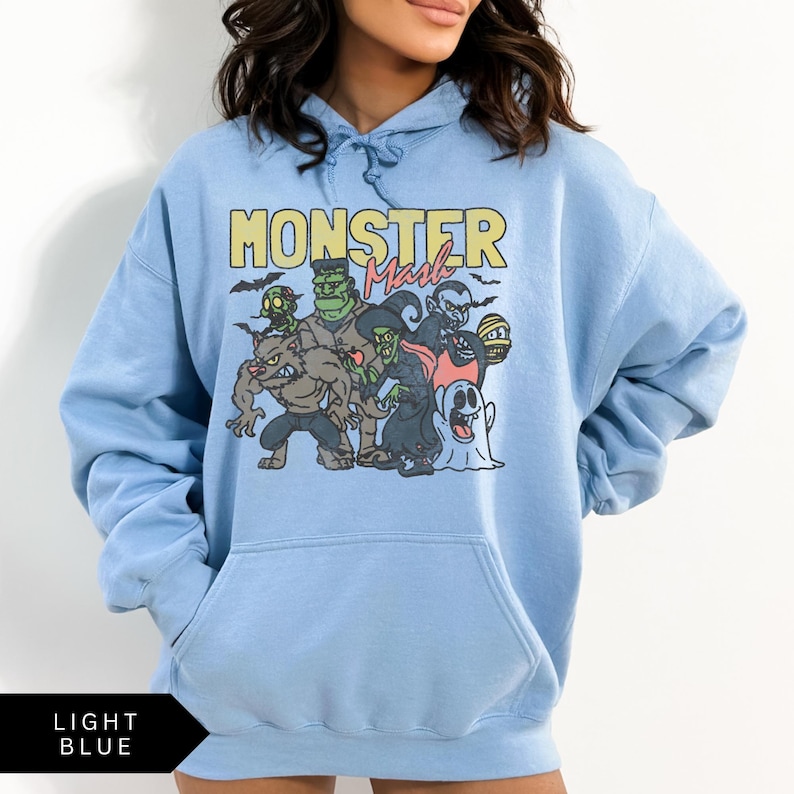 Puede incluir: Sudadera con capucha azul claro con un estampado gr&aacute;fico de monstruos de dibujos animados y el texto "Monster Mash".