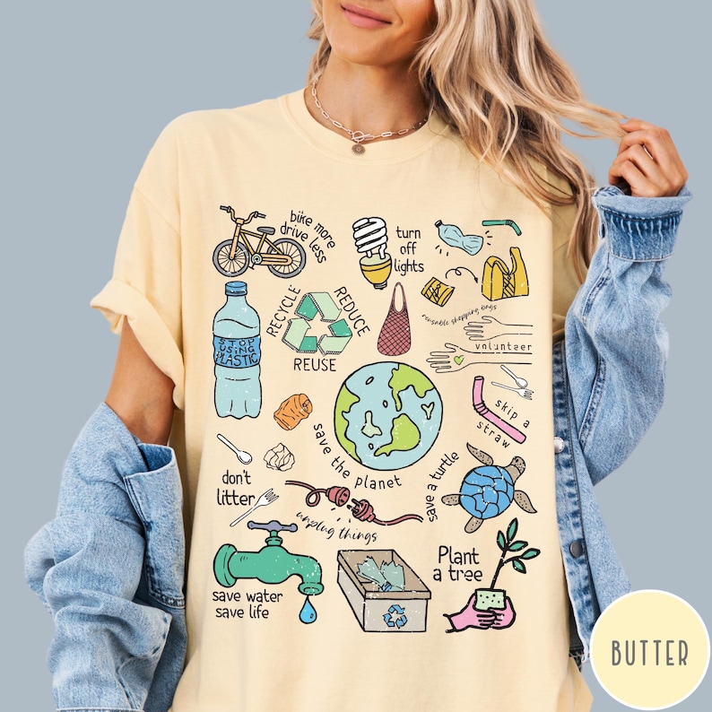 May include: A yellow t-shirt featuring a colourful illustration of various ways to help the environment. The illustration includes a bicycle, a lightbulb, a recycling symbol, a globe, a turtle, a tree, and the words "save the planet".