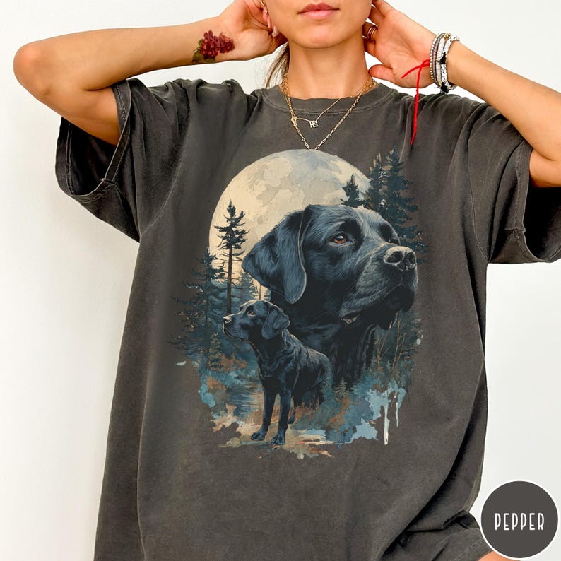 May include: Dark gray t-shirt featuring a detailed illustration of a black Labrador Retriever with a full moon and forest background. The design includes two Labrador portraits, one large and one smaller, with a Pepper logo.