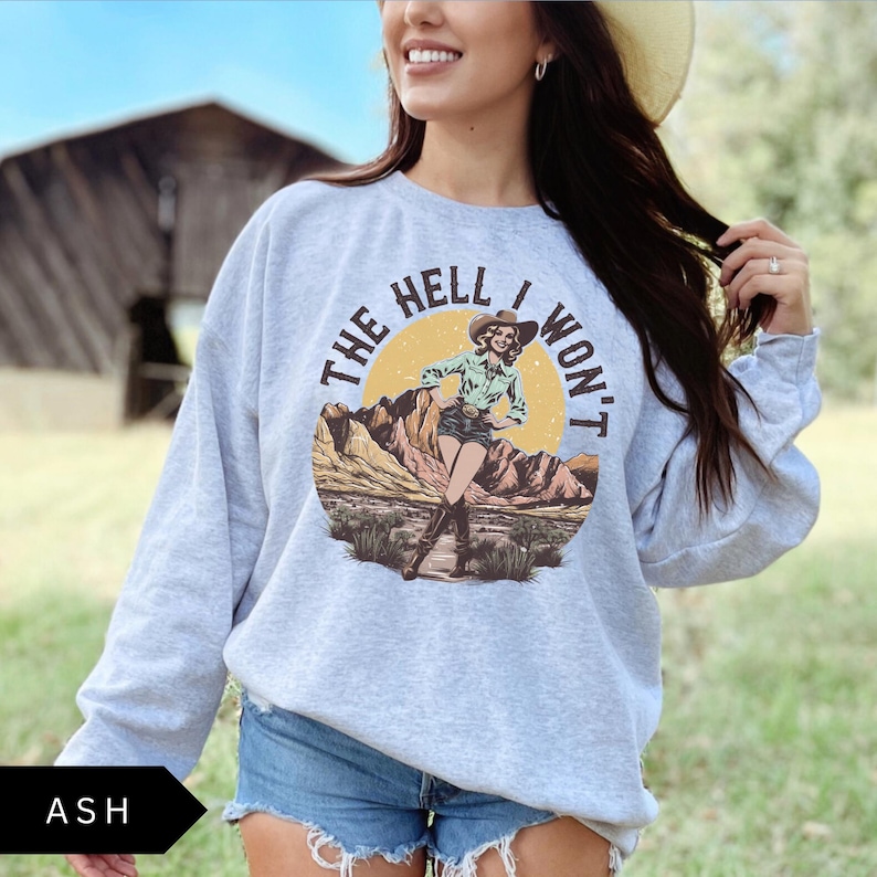 May include: Gray sweatshirt with a graphic of a woman in a cowboy hat and the text "The Hell I Won't".