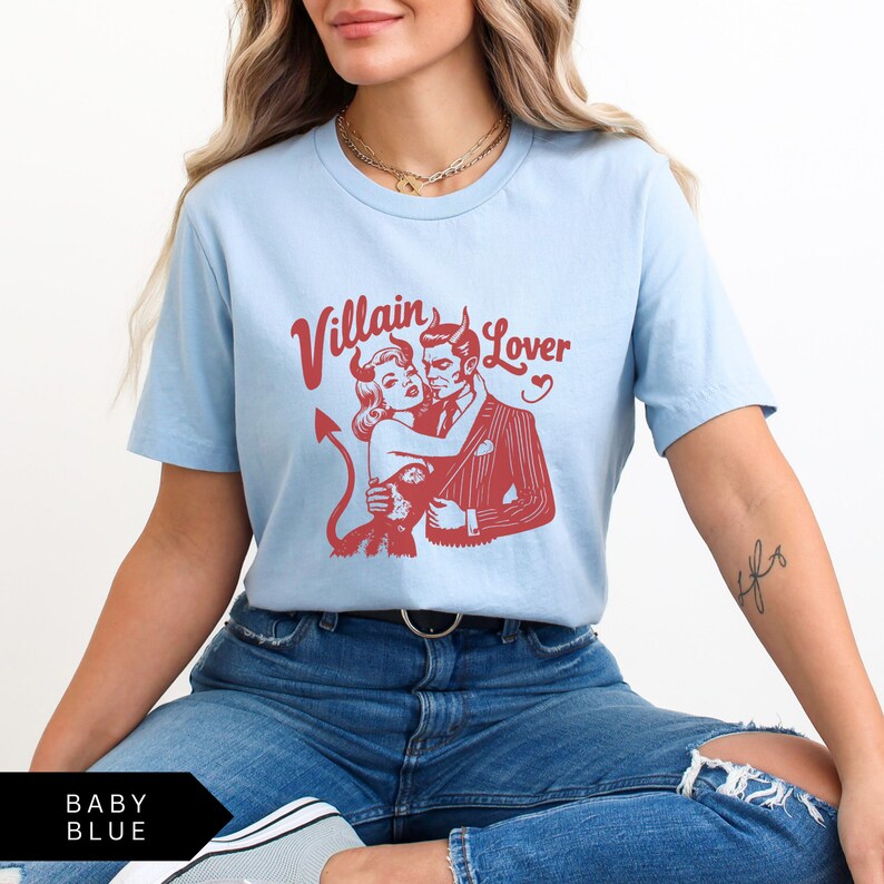 May include: A light blue t-shirt with a red graphic of a couple in a vintage style. The text "Villain Lover" is printed in red above the graphic.