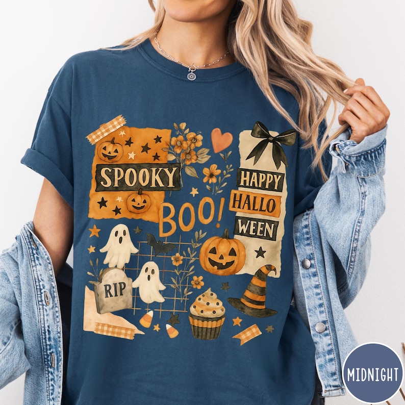 Op de afbeelding: Marineblauwe t-shirt met een Halloween-thema. Het ontwerp bevat pompoenen, geesten, een heksenhoed en de zinnen "Spooky Boo!" en "Happy Halloween." Het shirt heeft een relaxte pasvorm en korte mouwen.