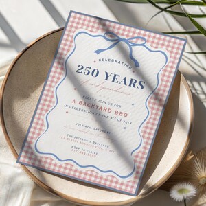 K&ouml;nnte beinhalten: Eine patriotische Einladung zu einem Grillfest im Garten, zum 250-j&auml;hrigen Jubil&auml;um der Unabh&auml;ngigkeit. Das Design zeigt einen blau-wei&szlig;en Vichy-Rand, eine blaue Schleife und Text in einer klassischen Schriftart.