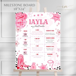 May include: Pink milestone board with the text "Layla my first rodeo." The board includes the baby's weight of 28 pounds, height of 35 inches, and other details. Decorative elements include a cowboy hat and boots.