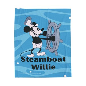 May include: A blue blanket featuring Mickey Mouse as Steamboat Willie, steering a ship's wheel. The blanket has a light blue background with wave patterns and the text "Steamboat Willie".