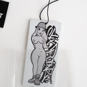 May include: A black and white illustration of a woman wearing a hat and boots. The woman is standing in front of the text "Sixty Point".