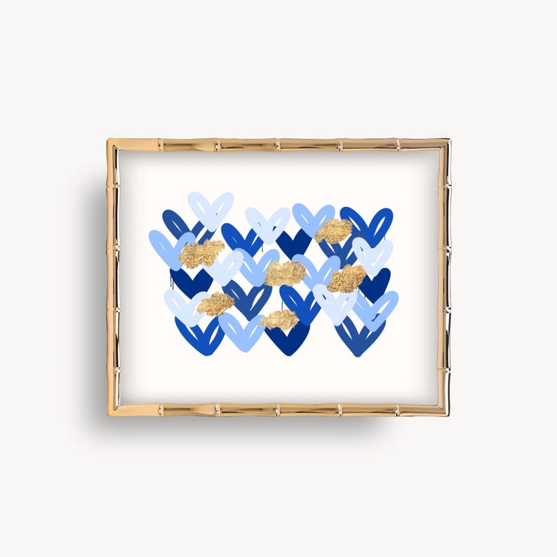 Peut inclure: Une impression encadr&eacute;e avec un motif abstrait bleu et or. Le motif pr&eacute;sente un motif de c&oelig;urs superpos&eacute;s dans des nuances de bleu avec des accents dor&eacute;s.