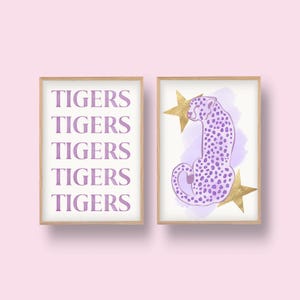 May include: Two framed prints, one with the word "TIGERS" repeated five times in a purple font, and the other with a purple cheetah sitting on a pink watercolor background with gold stars.