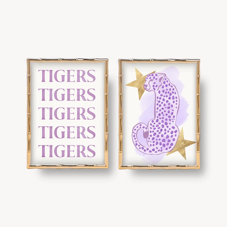 May include: Two framed prints with a gold bamboo frame. The print on the left has the word "TIGERS" repeated five times in a purple color. The print on the right has a purple cheetah with gold stars on a light purple watercolor background.