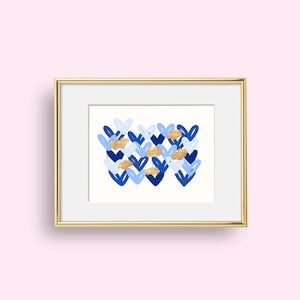 Peut inclure: Une impression encadr&eacute;e avec un motif abstrait bleu et or repr&eacute;sentant un motif de c&oelig;urs qui se chevauchent. Les c&oelig;urs sont dans des tons de bleu et le fond est blanc.