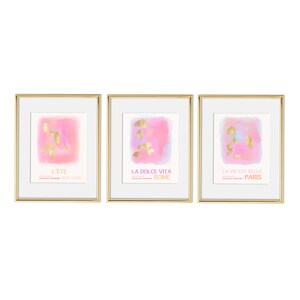 May include: Three framed prints with pink watercolor backgrounds and gold foil accents. The prints feature the text "L'ete New York", "La Dolce Vita Rome", and "La Vie Est Belle Paris".