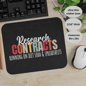 Pode incluir: Tapete de rato preto com o texto "Research CONTRACTS RUNNING ON DIET SODA & SPREADSHEETS" em branco, laranja, vermelho e azul. O tapete de rato mede 22,86 cm x 20,32 cm e tem 0,16 cm de espessura.