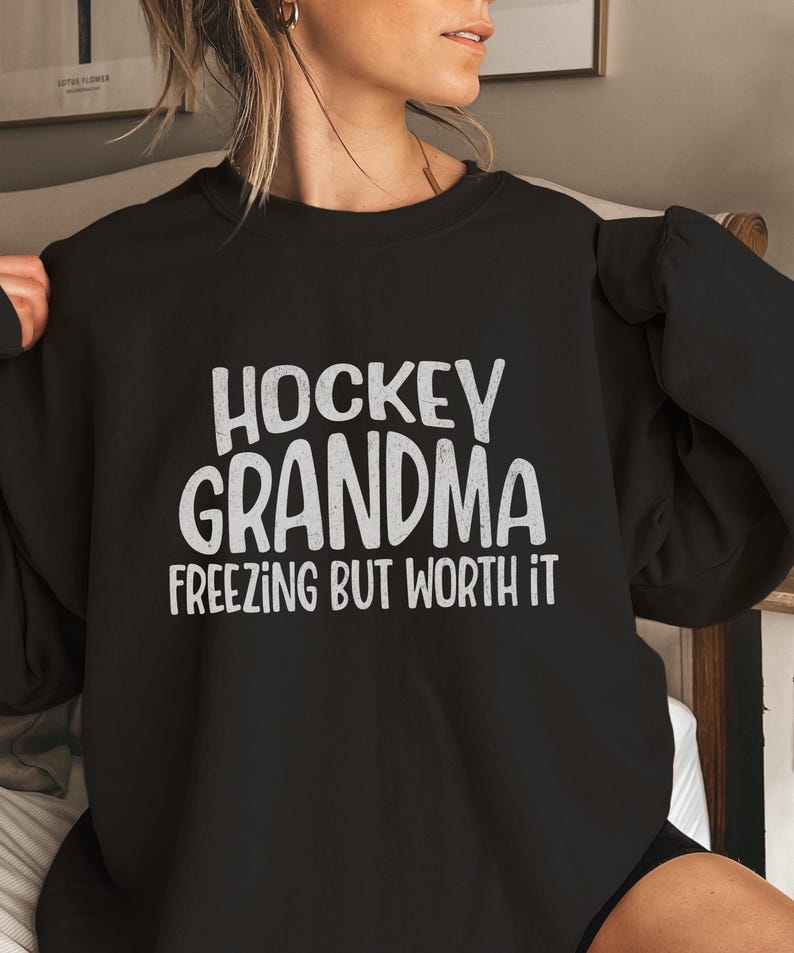 May include: Black sweatshirt with the text "Hockey Grandma Freezing But Worth It" in white.