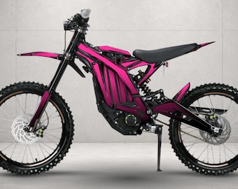 May include: A dirt bike featuring a vibrant pink frame and body panels with black accents. The motorcycle is equipped with black spoked wheels, knobby tires, a black seat, and a kickstand. The design includes a front fender and disc brakes.