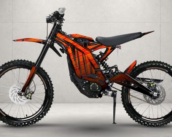 May include: An electric dirt bike featuring a black frame and a vibrant orange graphic wrap with thin black vertical lines. The motorcycle is equipped with knobby tires, disc brakes, a black seat, and a kickstand, presented in a side profile view.