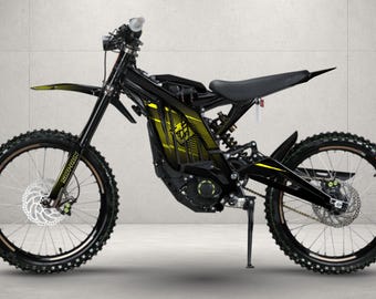 May include: A black electric dirt bike featuring a yellow graphic design on the frame, a black seat, front and rear disc brakes, knobby tires, and a kickstand. The bike has a suspension fork and a rear shock absorber, with yellow accents on the front forks.
