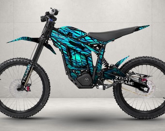 May include: An electric dirt bike featuring a vibrant cyan and black abstract graphic wrap. The frame displays the text Talaria on the front fork and Sticky Upgrade on the rear swingarm. It has black spoked wheels, a black seat, and a motor.