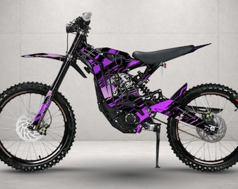 May include: An electric dirt bike featuring a black frame with vibrant purple and white graphic decals. The design includes a stylized panther head illustration on the main body, black spoked wheels, a black seat, and disc brakes on both wheels.