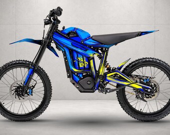 May include: An electric dirt bike featuring a vibrant blue and yellow graphic wrap on the frame. The motorcycle has black handlebars, a black seat, knobby tires, front and rear disc brakes, and a central battery housing with a black motor cover.