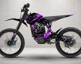 May include: An electric dirt bike featuring a black and purple graphic wrap with a tiger illustration on the frame. The bike includes a black seat, knobby tires, front and rear disc brakes, and a suspension system. The word Talaria is visible.