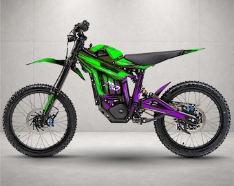 May include: An electric dirt bike featuring a vibrant green and purple graphic wrap on the frame and body panels. The motorcycle has black spoked wheels, knobby tires, a black seat, and a black frame with visible suspension and disc brakes.