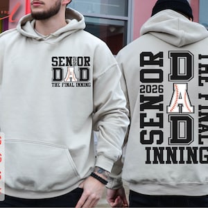 Puede incluir: Una sudadera con capucha gris con el texto "Senior Dad 2026 The Final Inning" en la parte delantera y "Senior Dad 2026 The Final Inning" en la parte trasera. El texto está en blanco y negro con un gráfico de béisbol.