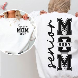Może przedstawiać: Biała bluza z napisem "Senior MOM 2027" czarnymi literami na przodzie i z tyłu. Tył bluzy ma napis "Senior" w pionowym skrypcie. Bluza to swobodny element garderoby.