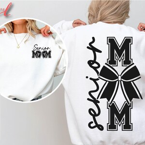 May include: White sweatshirt with black text that says "Senior Mom" with a cheer bow and the letters "M-O-M" on the back.