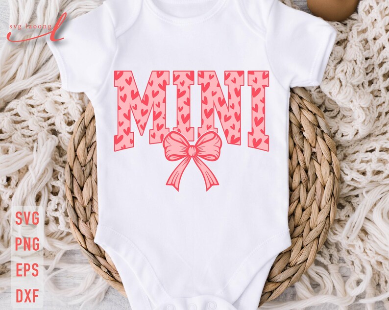 May include: White baby onesie with the word "MINI" in pink letters with a pink heart pattern. A pink bow is below the word.