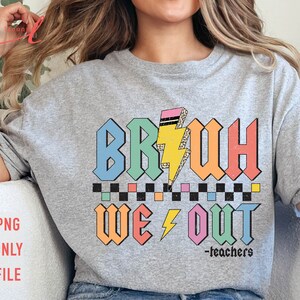 Peut inclure: Un t-shirt gris avec un motif color&eacute; qui dit "BRUH WE OUT -teachers". Le motif est de style r&eacute;tro avec un &eacute;clair et un motif &agrave; carreaux.