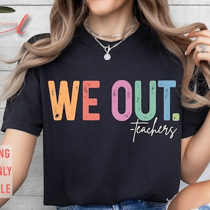 May include: A black t-shirt with the text "WE OUT. Teachers" in rainbow colors. The text has a distressed, vintage look.