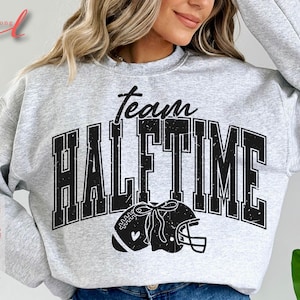 May include: Gray sweatshirt with black text that reads "Team Halftime" with a football helmet graphic.