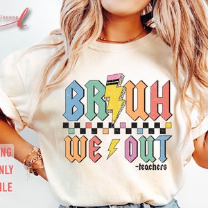 Peut inclure: Un t-shirt blanc avec un graphique color&eacute; qui dit "BRUH WE OUT -teachers". Le graphique est dans un style r&eacute;tro avec un &eacute;clair et un motif &agrave; carreaux.