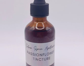 Peut inclure: Une bouteille en verre brun avec un compte-gouttes noir. La bouteille porte une étiquette blanche sur laquelle est inscrit "Silver Spoon Apothecary Passionflower Tincture".