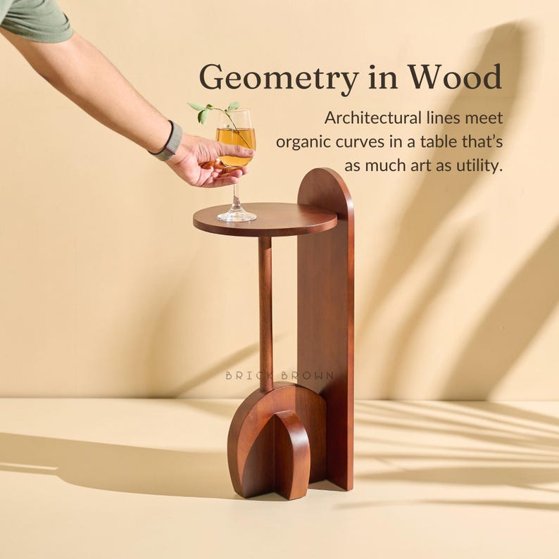 May include: A dark brown wooden side table with a circular top and a curved base. The table has a tall, slender stem and a vertical support. The text "Geometry in Wood" is visible.