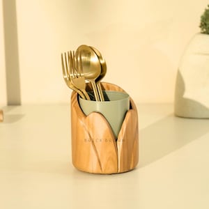 May include: A wooden utensil holder with a light green interior, holding gold-colored forks and spoons. The holder has a natural wood grain finish and the text "BRICK BROWN" is visible on the front.