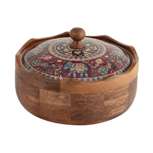 May include: A round wooden box with a lid. The lid is decorated with a colorful pattern of elephants, peacocks, and floral designs on a red background. The box is made of light brown wood.
